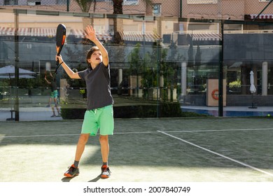 10-year-old boy practicing paddle on a residential paddle court, front view