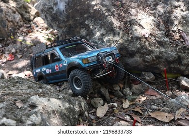 1:10 Scale Rc Adventure, A Navy Blue Toyota Land Cruiser Trying To Climb A Rock Using A Winch (gresik, 28 August 2022)