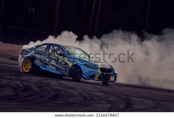 11-05-2022 Riga, Latvia car\
drifting on asphalt racing track with lot of smoke, motion blur\
drift car.