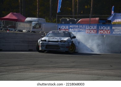 11-05-2022 Riga, Latvia A Car With Smoke Coming Out Of It Driving On A Track, A Car Is Doing A Burn While It's Driving On A Track.