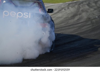 11-05-2022 Riga, Latvia A Car With A Lot Of Smoke Coming Out Of It, A Racing Car With A Smoke Trail Coming Out Of Its Hood.