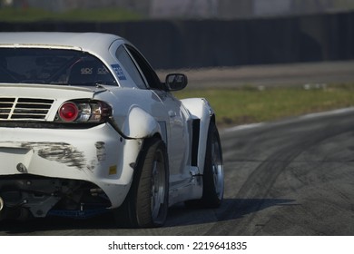 11-05-2022 Riga, Latvia A White Sports Car Is On A Race Track, The Back End Of A Car That Is In A Race Track.