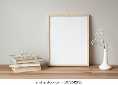 11x14 thin wood vertical frame mockup for art and quotes. Vintage stack of books and flowers as props.