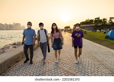 12 9 2022 Youngsters Students Boy And Girl Chat And Walk During Sunset In West Kowloon Waterfront Promenade, Hong Kong In Evening. Back Light Shot