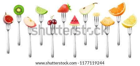 12 isolated fruit pieces. Cut fig, apple, kiwi, lemon, grape, orange, lime, strawberry, watermelon, banana, pineapple and pear on a steel dessert fork isolated on white background with clipping path
