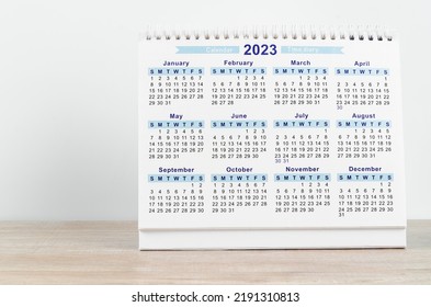 12 months desk calendar 2023 on wooden background.