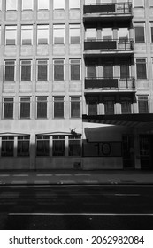 12 Sep 2021 - London\uk: Black And White Monochrome Image Of Facade Of 1980s Office Building With Balconies On Empty Street Under High Contrast Shadowing Cast Over The Exterior On Sunny Day