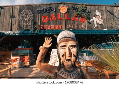 12 September 2020, Kemer, Turkey: Dallas Steak House Restaurant Exterior With Native American Wooden Statue At The Entrance