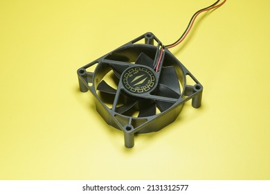 12 Volt DC Black Cooling Fan On Yellow Background Isolated