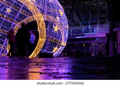 12/15/2019 Portsmouth, Hampshire, UK A Group Of Teenagers Standing Under A Lit Christmas Decoration In A City Centre