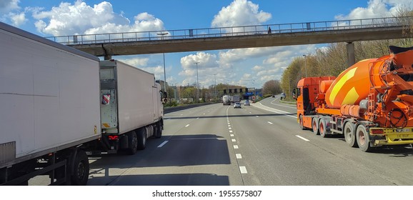 13 April 2021 Belgium, Antwerp, Motorway With Double Trailer Truck And Orange Concrete Mixer