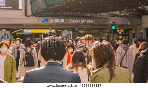13 March\
2021 - Osaka, Japan. Crowd people with mask cross the road to go to\
the station while in Corona situation.\
