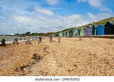 13 May 2015 A Family Enjoying A Day Out On The Powdered Shell And Pebble Beach On The Hampshire Coast Near Titchfield In The South Of England. Traditional Colourful Beach Huts Look Out To Sea