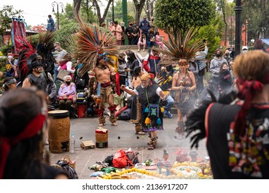 13.02.2022 - Mexico, Coyoacan. Conchero. Mexican Indians In Traditional Clothes Costumes Dance Aztec And Perform On Street. Musicians Playing Drums Near Altar With Smoke. Old Woman Performing 