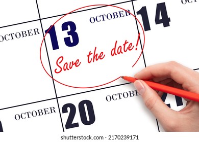 13th day of October. Hand drawing red line and writing the text Save the date on calendar date October 13.  Autumn month, day of the year concept.