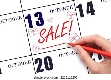13th day of October. Hand writing text SALE and drawing gift boxes on calendar date October 13. Shopping Reminder. Online shopping. Autumn month, day of the year concept.