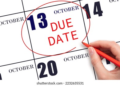 13th day of October. Hand writing text DUE DATE on calendar date October 13 and circling it. Payment due date. Business concept. Autumn month, day of the year concept.