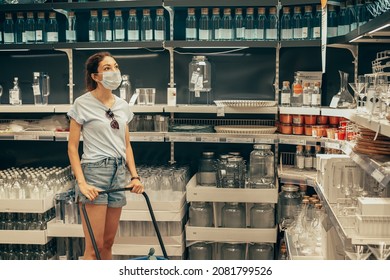 14 June 2021, Ufa, Russia: Woman In A Protective Mask During The Covid Pandemic Chooses And Buys A Glassware And Other Kitchen Utensils In The IKEA Shopping Center