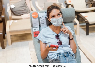 14 June 2021, Ufa, Russia: The Woman In Face Mask Sat Down On A Chair And Thought About Buying In An IKEA Store