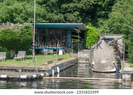 14 June 23 A small boat in a private inlet berthed on the Thames at Henley-on-Thames in Oxfordshire, the site of the Royal Regatta, on a fine summer afternoon