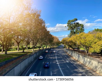 14 May 2020, Melbourne Australia: An Aerial View Of Cars Driving Away On Road Under Beautiful Blue Sky. Road With Safety Rail.