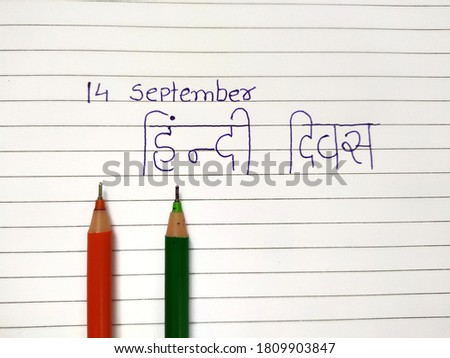 14 September hindi divas concept with orange and green pen on book's paper Translate 'Hindi divas'