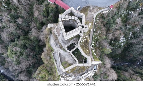 A 14th-century castle nestled between mountains, surrounded by lush greenery. The castle, known as Zil Kale, is an ancient fortress with a rich history, offering a scenic view of the natural landscape - Powered by Shutterstock