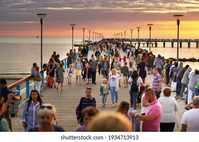 15 August 2017, Palanga, Lithuania. Wooden pier with lots of people by the sea at sunset.