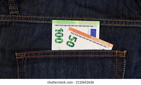 150.00 euros consisting of a 100.00 euros and a 50.00 euros banknote in close-up in the back pocket of dark blue jeans - Shutterstock ID 2110652636