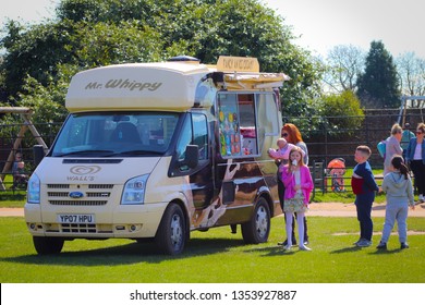15/05/2017 Surrey, England. Woman buying soft ice-cream for herself and her kids from Mr Whippy Van during warm day in England.