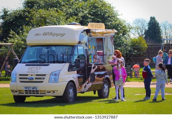 15/05/2017 Surrey, England. Woman buying soft
ice-cream for herself and her kids from Mr Whippy Van during warm
day in England.