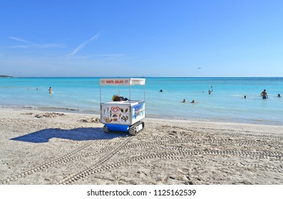 15.07.2017. Livorno Rosignano, Italy. Promotion Vehicle  Car Selling Ice Cream On The Paradise  Beach With White Send And People In Sea Water.