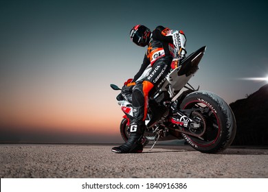 15.10.20, California, USA. The Driver In A Motorcycle Jacket And Helmet Is Sitting On A Sportbike, Looking Back. Rear View. Twilight. Copy Space