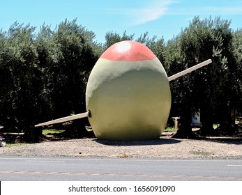 A 15-foot-tall green olive skewered by a similarly supersized red toothpick. Sits at the edge of an olive grove in honor of Corning, the Olive City. Roadside attraction in California's central valley.