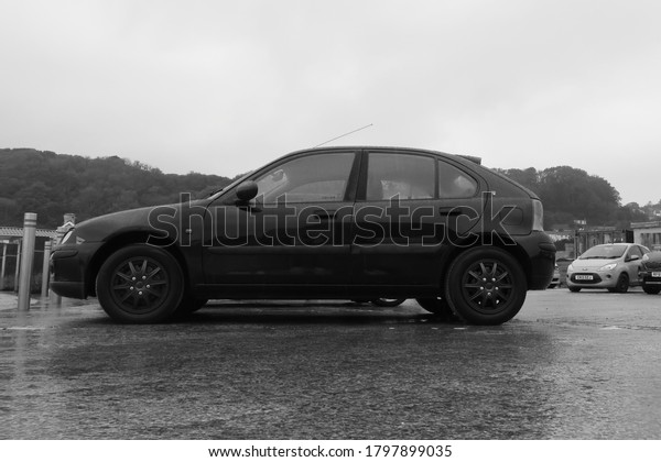 15th August 2020- An old Ford 25 16v, five door\
hatchback car, parked in the rain in the public carpark at Pendine,\
Carmarthenshire, Wales,\
UK.