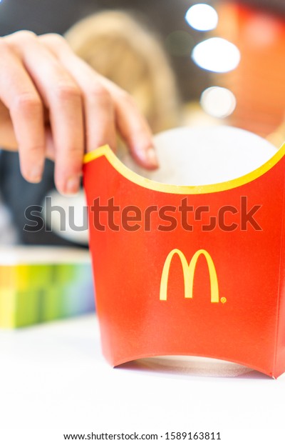 15th -
December -2019 - Stoke on Trent, Staffordshire, A customer picks up
an empty French fries box at McDonalds after a family trip to the
famous fast food retailer, Golden
Arches