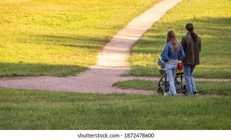 16.09.2020, Moscow, Russia. Young parents and their baby walking in the summer park. People on the nature.