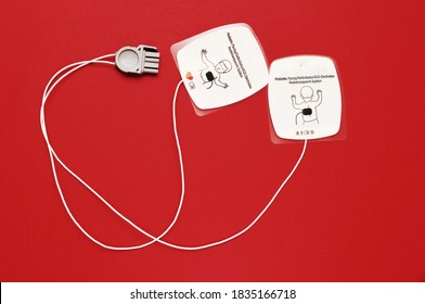 17 October 2020, Dubai, UAE -Pediatric Combo Pads Used For Defibrillation.Defibrillation Usually Given During Cardiac Arrests To Save Lives .Image Isolated On A Red Background 