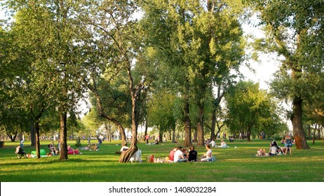 17.09.2017 - Kyiv, Ukraine. Crowd of people relaxing on the city park lawn. People resting sitting on grass in public park.