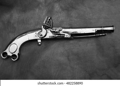 1730 era Scottish Highland Black Powder Flint Lock Pistol - Murdoch Style. isolated on a leather background. converted to black and white
