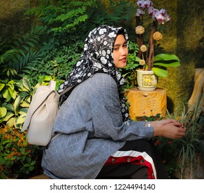 18 3 2018: Indonesia Domestic Helper  Posing For Photos In Hong Kong Botanical Garden. Weekends Helpers From Indo Philippine Enjoy Their Only Day Off: Eating, Dancing, Styling Hair, Reading Book