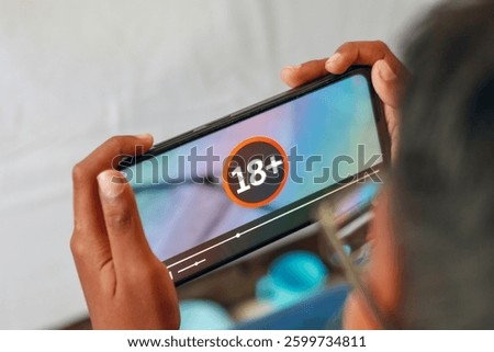 18 plus content warning displayed on a smartphone screen in close up view
