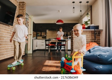 18.11.2018 Vinnitsa, Ukraine: Two Little Brothers Playing At Home, Running Around The Kitchen, Helping Mom With Cooking, Playing Home Games