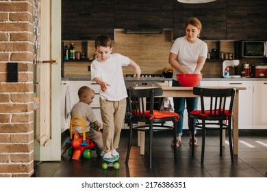 18.11.2018 Vinnitsa, Ukraine: Two Little Brothers Playing At Home, Running Around The Kitchen, Helping Mom With Cooking, Playing Home Games