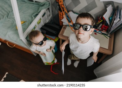 18.11.2018 Vinnitsa, Ukraine: Two Little Brothers Playing At Home, Running Around The Kitchen, Helping Mom With Cooking, Playing Home Games