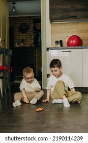 18.11.2018 Vinnitsa, Ukraine: Two Little Brothers Playing At Home, Running Around The Kitchen, Helping Mom With Cooking, Playing Home Games