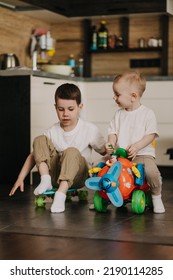 18.11.2018 Vinnitsa, Ukraine: Two Little Brothers Playing At Home, Running Around The Kitchen, Helping Mom With Cooking, Playing Home Games