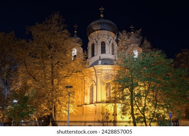 1869 Metropolitan Cathedral of Saint Mary Magdalene Orthodox church facade with Christian crosses on top of the domes illuminated at night in the Praga borough Warsaw, Poland.