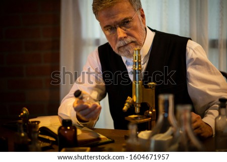 1885 scientist thinking while holding a drug