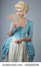 18th Century woman in blue bodice and cream skirt